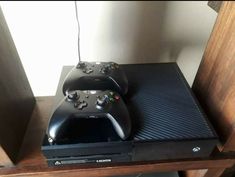 two video game controllers sitting on top of a shelf