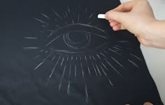 someone drawing an eye on a t - shirt