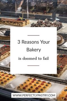 three trays filled with different types of cakes and pastries on display in a bakery