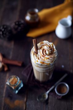 a hot chocolate drink with whipped cream and cinnamon sticks