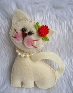 a white cat with a red flower on its head