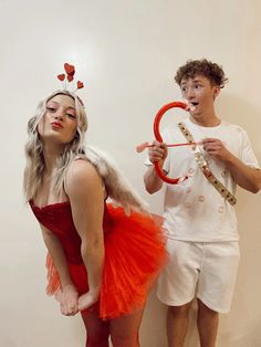 a man and woman dressed in costumes standing next to each other with scissors on their heads