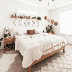 a bedroom with white walls and lots of potted plants on the wall above the bed