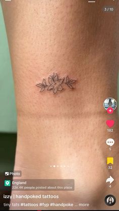 a small tattoo on the side of a woman's lower leg, with flowers and leaves