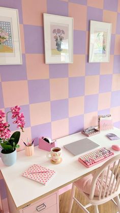 a pink and purple room with checkered wall paper on the walls next to a desk