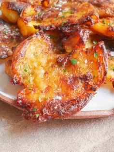 some fried food on a white plate with parsley sprinkled around the edges