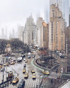 a city street filled with lots of traffic and tall buildings covered in snow during the day