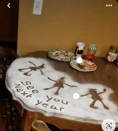 a wooden table topped with a cake covered in frosting and two small plates on top of it