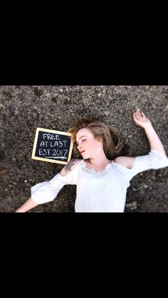 a woman laying on the ground next to a sign that says first time at last