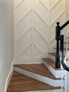 a staircase with white painted walls and wooden steps