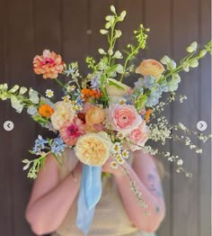 a woman holding a bouquet of flowers in her hands