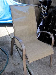 a chair that is sitting on the ground next to some golf bags and a bag