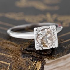 A beautiful and chonky Peruzzi cut diamond solitaire in white gold! The center stone is giving us classic Peruzzi vibes with her tiny table, making It look like quite the sparkly ring pop. She’s light fancy yellow-brown in color, which we find to look so warm and radiant in the white gold gold prong setting. The perfect antique solitaire, just beyond charming on the finger. 14kt white gold Size 5.5 & fully resizable Diamond is estimated to be fancy yellow brown, VS1 clarity. GIA standards. Pleas Silver Diamond Ring With Radiant Rose Cut, Silver Single Diamond Ring For Proposal, Silver Rings With Single Cut Diamonds For Proposal, Tiny Table, Modern Mens Rings, Art Jewelry Earrings, Table Making, Ring Pop, Sparkly Ring