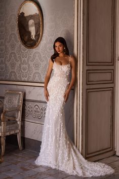 a woman in a wedding dress leaning against a wall