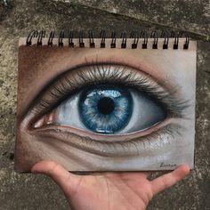 a drawing of an eye is shown in the palm of a person's hand