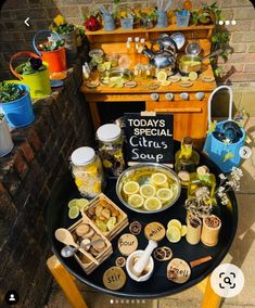 a table topped with lots of food on top of a wooden table next to a brick wall