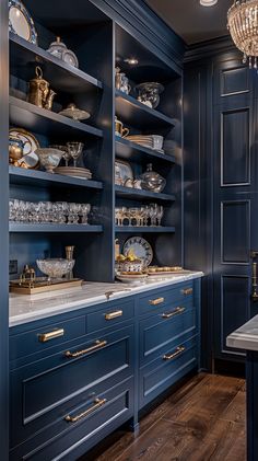 a kitchen with blue cabinets and gold trimmings on the doors, counter tops and shelves