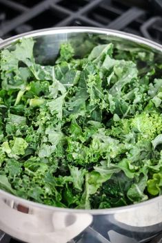 a pot filled with green vegetables on top of a stove