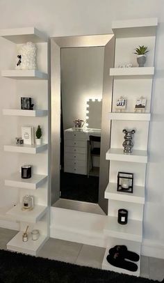 a mirror sitting on top of a white shelf next to a black and white rug