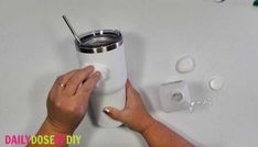 someone is holding the lid on a white tumbler cup while it's being held by their hands