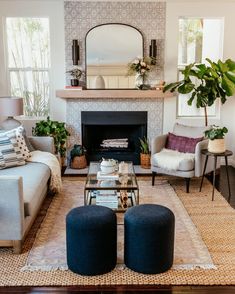 a living room with couches, chairs and a mirror on the fireplace mantel