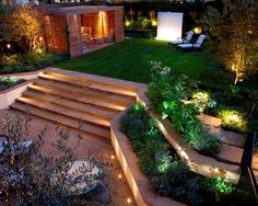 an outdoor garden with steps lit up at night