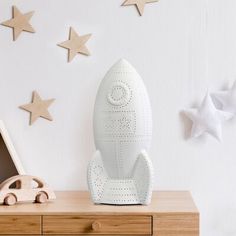 a toy rocket ship sitting on top of a wooden dresser