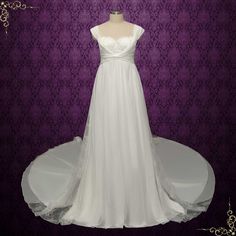 a white wedding dress on display in front of a purple background