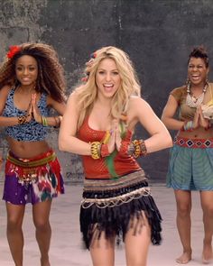 a group of women dancing around each other