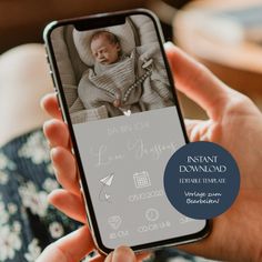 a person holding up a cell phone with an image of a baby on it