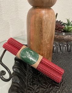 a close up of a wooden object on a table with a plant in the background