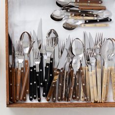 a wooden box filled with lots of silverware