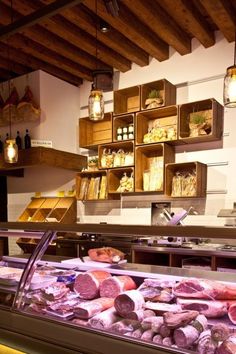 meats and cheeses are displayed in the display case at a deli counter