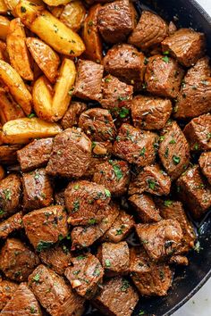 meat and potatoes in a skillet with parsley on the side, ready to be eaten