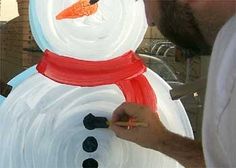 a man is painting a snowman with paint