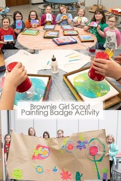 children are sitting around a table with paintings on it and holding cups in front of them