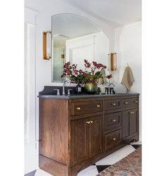 a bathroom vanity with two sinks and mirrors