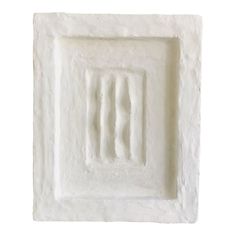 a white square shaped object is shown on a white background, it appears to be made out of cement