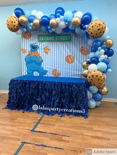 sesame street balloon arch with cookie cookies and blue tassels on the front table