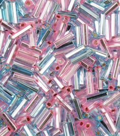 many pink and blue beads are scattered on top of each other in this image,