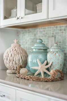 decorative jars and seashells are on the kitchen counter