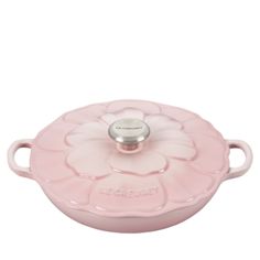 a pink casserole dish with a flower design on the front and bottom,