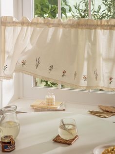 a table with food and drinks on it in front of a window