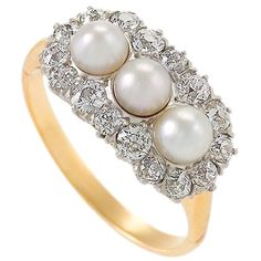 This romantic ring is perfectly Edwardian, with its triplet of creamy, lustrous pearls, center-set in platinum amongst a nest of brilliantly sparkling diamonds. The balance between the the milky pearls and the scintillating diamonds creates a unique effect, with the ring’s graceful form allowing the gems to float delicately on the finger. Circa: 1910 Size: 7.25 (this ring may be resized, please contact us for further information) Materials: 15 Old European-cut diamonds (approximate total weight of 0.85 carat); 3 Pearls; Platinum-topped 14K gold; 14K Gold shank (shank added later) Diamond And Pearl Ring, Romantic Rings, Vintage Cocktail Ring, Pearl And Diamond Ring, Vintage Cocktail, European Cut Diamonds, Pearl Diamond, Diamond Cluster Ring, Three Stone Rings