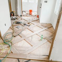 an unfinished room with wood flooring and construction tools on the ground in front of it