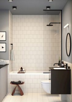 a bathroom with a toilet, sink and bathtub next to a mirror on the wall