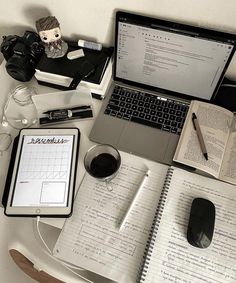 an open notebook sitting on top of a table next to a laptop computer