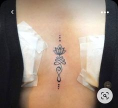 a woman's back with a tattoo design on her left side ribcage