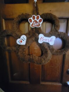 a dog door hanger decorated with paw prints and i love bark stickers on it