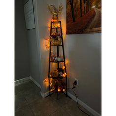 a tall shelf with candles on it next to a painting